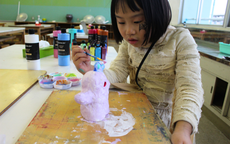 ACES Girl in Afterschool Pottery class, painting her own pottery