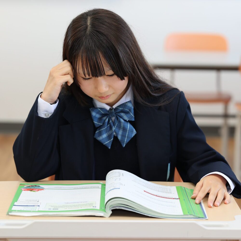World-Class academics and education being taught at One World International School. A secondary school student read a textbook and thinks deeply (thinking)