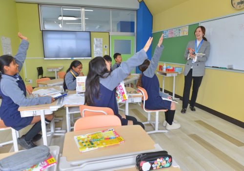 Students with hands up at One World International School Tsukuba